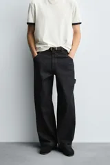 Pantalón de jean negro de corte amplio, con bolsillos delanteros y traseros, presilla portaherramientas en la pierna derecha y costuras a contratono.