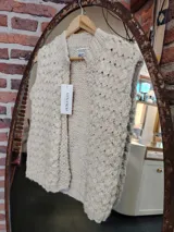 Chaleco tejido de lana merino color crema, con cuello alto y diseño artesanal con textura en relieve.
