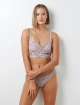 Conjunto de lencería color lila, compuesto por un bralette de encaje floral sin aro ni relleno, con breteles regulables y cierre trasero, y una bombacha tipo colaless de encaje floral con elástico fino.