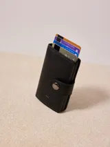 Billetera tarjetero pop up Rusty, color negro, confeccionada en cuero sintético.