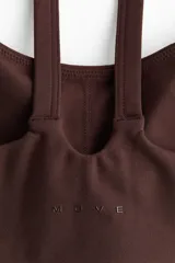 Top deportivo marrón de breteles con escote redondo y copas forradas con relleno extraíble.