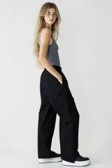 Pantalón negro de tiro alto, corte palazzo y bolsillos laterales.