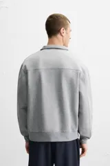 Sudadera negra de cuello alto con cierre frontal de cremallera, corte relaxed fit, manga larga y terminaciones en rib.