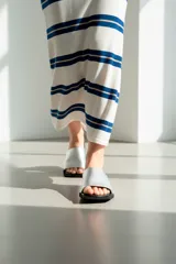 Sandalias plateadas de cuero con suela plana negra y puntera cuadrada.