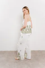 Pantalón blanco con estampado geométrico en azul y marrón, de calce relajado y caída fluida.