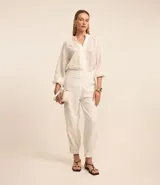 Pantalón zanahoria de cintura alta confeccionado en chiffon con bordados florales. Presenta cintura ancha y cierre lateral con cremallera.