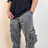 Pantalón jean cargo gris oscuro, corte holgado, con bolsillos laterales y traseros.