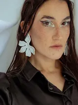Par de aros con forma de flor roja brillante y detalle de strass plateado en el centro.