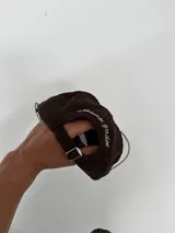 Gorro tipo gorra de béisbol color marrón, confeccionado en pana, con visera corta y bordado frontal en blanco que dice "LOVE & PEACE" y "PP:ONE".