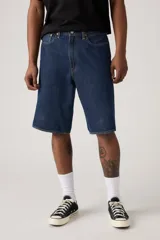 Bermuda de jean azul oscuro, corte holgado y largo hasta la rodilla.