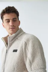 Campera de sherpa verde militar con cierre frontal y bolsillos laterales con cierre.