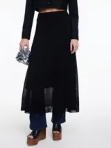 Falda larga evasé de punto con lurex, color negro. Confeccionada en tejido liviano con sutil brillo, tiene un corte evasé que acompaña el movimiento del cuerpo. Su diseño minimalista y su silueta fluida la convierten en una prenda versátil. Cintura plana y terminación ligeramente transparente en el ruedo.