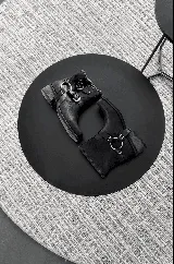 Botas cortas de cuero negro con arnés desmontable y hebillas plateadas.