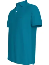 Chomba azul de Tommy Hilfiger, modelo 1985, de corte regular, con cuello tipo chomba, cartera de dos botones, logo bordado en el pecho y detalles distintivos de la marca. Confeccionada en mezcla de algodón y poliéster.