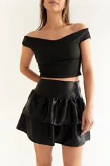 Minifalda negra con estampado abstracto en tonos dorados y volados.