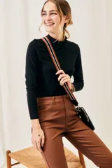 Polera negra de algodón y elastano, con cuello alto y mangas largas, corte ajustado al cuerpo.