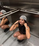 Gorro tipo casquete tejido a crochet color plateado, con apliques de perlas blancas.