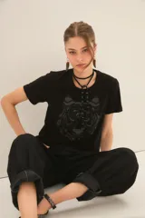 Remera de algodón color negro con cuello redondo y manga corta, caracterizada por una aplicación frontal con el diseño de un tigre.