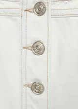 Chaleco crop de jean blanco con tirantes finos, escote cuadrado, cierre frontal con botones y bolsillos de parche en el pecho.