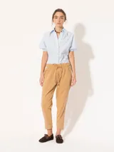 Pantalón babucha color verde militar, confeccionado en tejido de punto y plano. Tiene cintura elastizada con cordón ajustable y largo al tobillo.