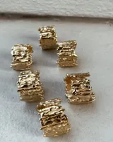 Anillo ancho de bronce con textura irregular.