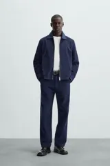 Pantalón de corte regular fit en color azul marino, confeccionado en una mezcla de lyocell y algodón. Presenta bolsillos frontales inclinados, bolsillos traseros de vivo y cierre frontal con cremallera y botón.