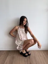 Vestido corto blanco con estampado tie-dye en tonos rosados, de corte suelto y breteles finos.