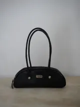 Cartera baguette con estampado animal print en tonos azul y marrón, con doble asa corta y cierre superior con cremallera.