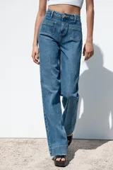 Pantalón de jean de tiro alto con bolsillos frontales y traseros. Corte recto y cierre frontal con cremallera y botón.