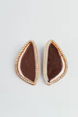 Par de aros colgantes con forma abstracta rellena de resina color marrón y bordes con strass.