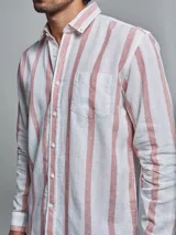 Camisa de lino blanca con rayas verticales color rosa, de manga larga y corte clásico.
