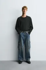 Pantalón de jean azul de corte recto y relajado, con bolsillos laterales tipo cargo con solapa.