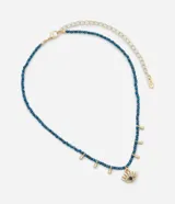 Collar corto con cuentas azules y colgantes dorados en forma de gota. Dije central con forma de ojo turco con detalles dorados y cristal azul.