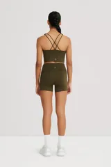 Top deportivo color beige, de cintura ancha, realizado en tela doble suave y de alta elasticidad. Detalle de breteles cruzados en la espalda.