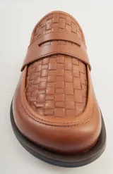 Mocasín mule de cuero negro con capellada tejida.