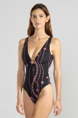 Traje de baño enterizo negro con estampado de cadenas y flores rosadas, escote en V con detalle de argolla dorada y espalda cruzada.