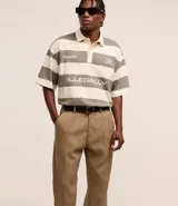 Pantalón de vestir marrón oscuro, de corte loose, con pliegues, bolsillos y cierre tradicional.