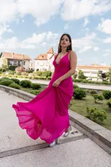 Vestido largo de crep fucsia con escote en V y falda amplia.