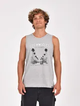Musculosa blanca de cuello redondo y sisa amplia, con un estampado frontal de estilo fotográfico en blanco y negro que muestra un paisaje desértico y una construcción, acompañado por la palabra "wilderness" en color verde.