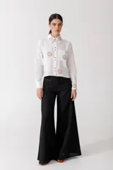Pantalón de lino color crudo con finas rayas verticales negras, corte wide leg y tiro alto.