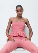 Top con tirantes finos, estampado de cuadros vichy rojos y blancos, bajo abullonado con volantes y cierre lateral con cremallera. Diseño entallado.