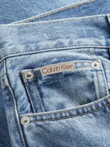 Pantalón de jean celeste de corte slim recto, con tiro medio, cinco bolsillos y cierre con cremallera.