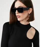 Blusa de punto negra con cuello redondo, manga larga y abertura circular en el hombro.