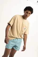 Remera color celeste con bolsillo en el pecho y logo estampado en color naranja.