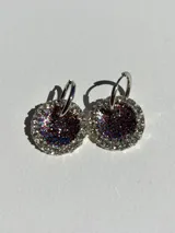 Aros colgantes con dije circular de resina con glitter multicolor y strass plateado alrededor.