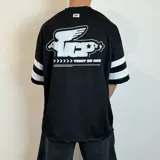 Remera negra estilo fútbol americano con cuello en V y mangas cortas con tres rayas blancas. Estampado frontal con logo y número 20 en blanco.