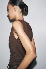 Top marrón de tejido de punto, sin mangas, con cuello fluido y detalle drapeado.