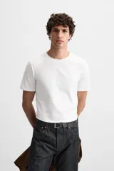 Camiseta slim fit de cuello redondo y manga corta, confeccionada en tejido de algodón con elasticidad.