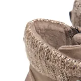 Borcego color taupe de símil gamuza, con caña media y cuello tejido con textura trenzada. Presenta cordones al tono con ojales metálicos, cierre interno, lengüeta acolchonada, punta redondeada, taco bajo símil madera y suela de goma antideslizante.