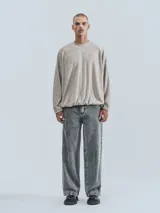 Sweater de tejido jaspeado color beige claro, con cuello redondo, mangas ranglán y elástico ajustable en el bajo.